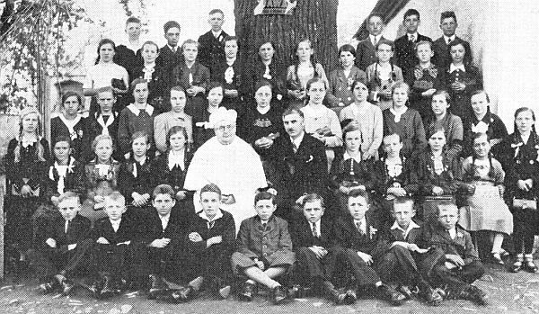 Na snímku se školní třídou v Slavkově sedí vedle řídícího učitele Franze Prenissla
