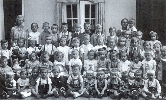 Na dvou krumlovských školních fotografiích už po roce 1938 je zachycen na té s bosými kamarády v popředí stojící pátý zprava, na druhé s hošíkem v vlaječkou "třetí říše" v prvé řadě je on ten ve třetí řadě docela nalevo zachycený žáček vedle dívenky s pannou