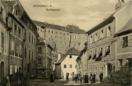 Pohlednice českokrumlovského nakladatele Eduarda Bayanda z roku 1910 zachycuje vpravo rodný dům čp. 48 v českokrumlovské Široké ulici (stojí před ním skupina lidí), na barevném snímku je rodný dům dnes (2019)