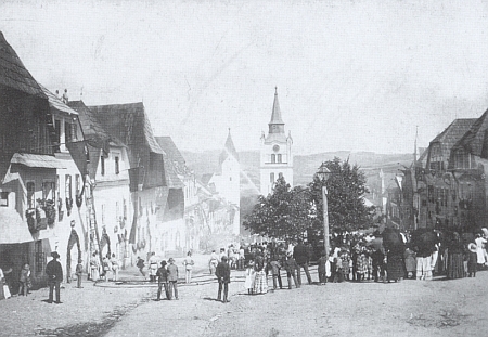 Dva snímky vimperského náměstí před osudným požárem - jeden z nich zachycuje cvičení hasičského sboru v roce 1898 a na obou je dům Ederových patrný podle vodorovného štítu