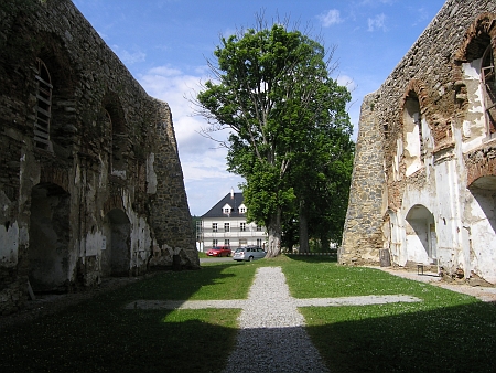 Pohled ze zřícené lodi kostele na jeden z nově postavených domů