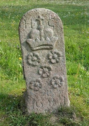 Hraniční kámen, oddělující českokrumlovské a rožmberské panství z roklu 1688 se znakem Eggenbergů, dnes umístěný u zámku Ohrada u Hluboké nad Vltavou