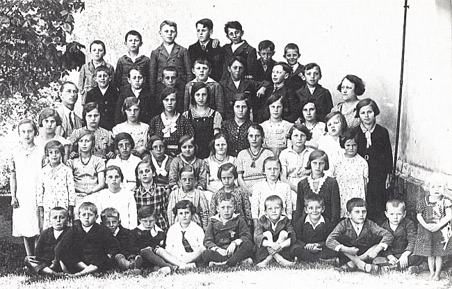 Stojí vlevo s žáky německé školy ve Věžovaté Pláni ve školním roce 1934/35