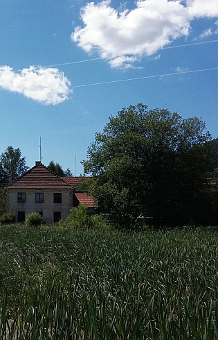 Rodný statek čp. 1 v Tisovce je v pohledu přes návesní rybník ten vpravo