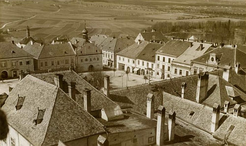 Pohlednice českokrumlovského fotoateliéru J. Wolfa zachycuje dům čp. 45 na novohradském náměstí (vlevo od svou věžičkou tak výrazné městské radnice)