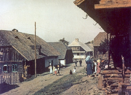 Kolorovaná pohlednice zachytila vesnickou ulici ve Stodůlkách