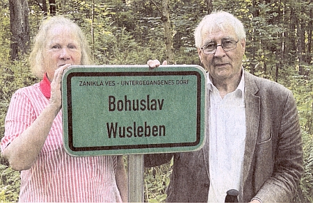 Zde je zachycena s Wolfem-Dieterem Hamperlem před novou místní tabulí zaniklé obce Bohuslav
