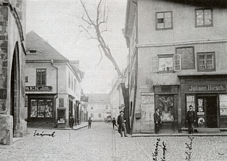 Tady stojí před svým obchůdkem na Kostelním náměstí v Prachaticích (první zprava)