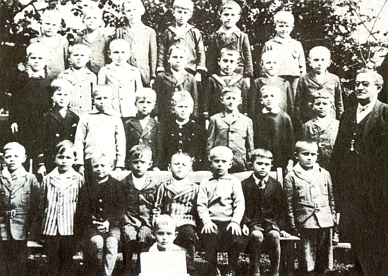 Pan řídící Josef Holl s dětmi 1. třídy německé obecné školy v Ronšperku v půli třicátých let 20. století