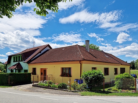 Dům čp. 27 v Chvalkově a podstavec kříže naproti němu