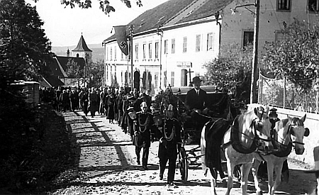 Snímek krumlovského fotografa Josefa Wolfa z Jungbauerova pohřbu v Horní Plané v říjnu válečného roku 1942 ve dvou verzích - na té spodní z krajanského měsíčníku je hákový kříž na praporu vyvěšeném na budově Šumavského muzea umně vyretušován...