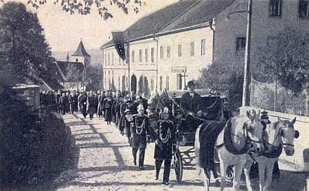 Snímek krumlovského fotografa Josefa Wolfa z Jungbauerova pohřbu v Horní Plané v říjnu válečného roku 1942 ve dvou verzích - na té spodní z krajanského měsíčníku je hákový kříž na praporu vyvěšeném na budově Šumavského muzea umně vyretušován...