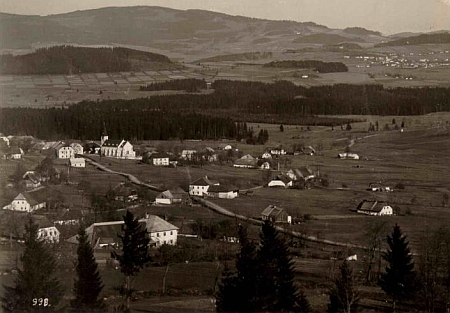 Pohlednice Josefa Wolfa zachycuje v popředí východní část zaniklé Zvonkové, kde stával rodný dům