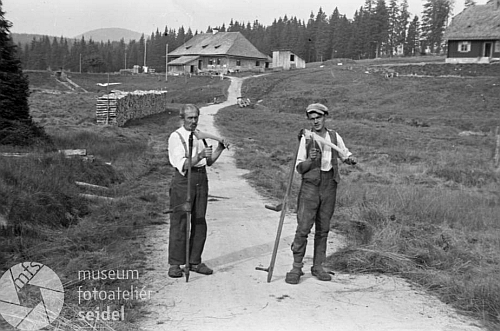 Tady figurují Franz Kortus mladší a starší na snímku z českokrumlovského fotoateléru Seidel s kosami před Roklanskou hájenkou v roce 1947