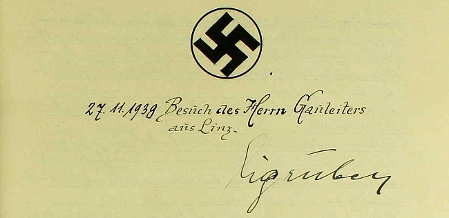Pečlivě vyvedený hákový kříž nad podpisem gauleitera Eigrubera na stránkách kroniky z neblahého podzimu 1938