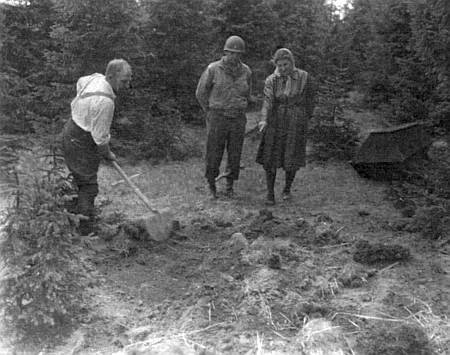 Jeden volarský civilista s lopatou na počátku exhumace těl židovských žen z pochodu smrti ve Volarech za dohledu židovského duchovního US Army Hermana Dickera a nejstarší z těch, které pochod přežily, tj. Miny Singerové - snímek byl pořízen 11. května roku 1945