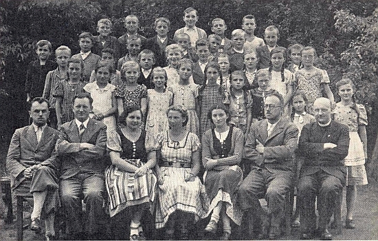 Tady sedí zcela napravo v první řadě na snímku z roku 1940 s učitelským sborem a jednou třídou "Hauptschule", tj. měšťanské školy ve Chvalšinách