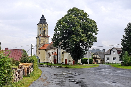 Náves v Mutěníně s kostelem na snímku z roku 2021