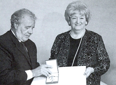 Ministerský rada Norbert Riedl jí tu 12. února roku 2004 ve Vídni předává zlatý záslužný odznak Rakouské republiky