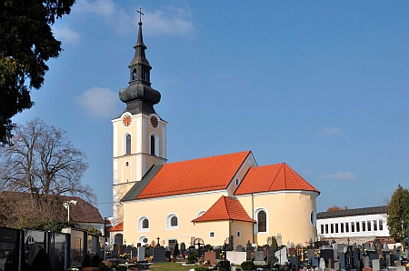 Farní kostel sv. Michaela v Leondingu s výrazným křížem na vrcholu věže a hřbitovem kolem