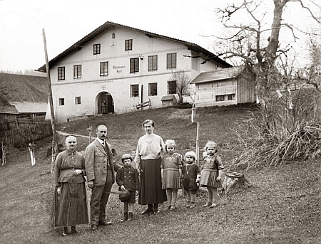 Mohutné selské stavení v zaniklé Havránce (Rabenhütte)
 a rodina Aloise Pangerla před ním na snímku z roku 1923