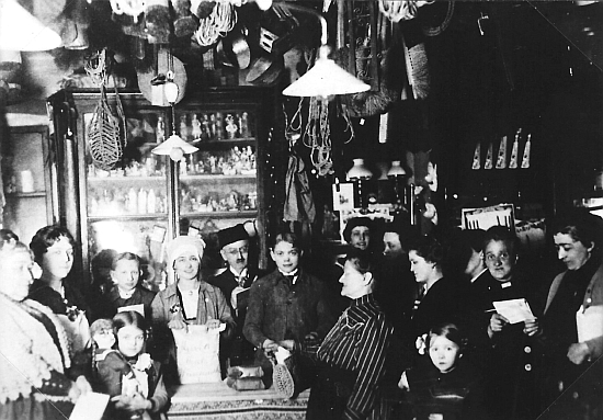 Rodiče na snímku v obchodě z válečného roku 1916, paní Buhlová drží papírový sáček s nápisem "Hurra, heute Mehlausgabe" (tj. "Hurá, dnes vydáváme mouku"); holčička s panenkou vpředu je tehdy osmiletá Marie Antonie Pruka, maminka Edith Lubosové, za ní vlevo pak babička - to vše pod elektrickým světlem díky elektrárně, postavené hrabětem Buquoyem