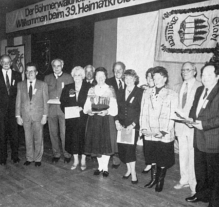 Tady stojí zcela napravo při ocenění dlouholetých spolupracovníků Böhmerwaldheimatkreis Prachatitz-Wallern-Winterberg u příležitosti rodáckého setkání v Ingolstadtu roku 1989 (zcela vlevo je tu zachycen Richard Schiefer, čtvrtá zprava zpola skryta Ilsa Viehbeck-Veithová)