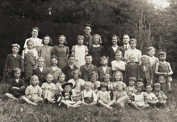 Sedí tu v kloboučku před prvními žáky netolické německé obecné školy roku 1940