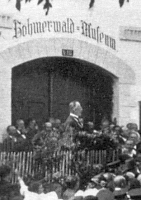 Vzácný snímek zachycuje Hanse Watzlika při slavnostním projevu k otevření Šumavského muzea v Horní Plané (předtím hostinec Blöckenstein) 8. července 1923
