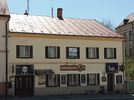 Rodný dům čp. 144 na kašperskohorském náměstí (dnes restaurace Pod Věží)je na snímku z kostelní věže ten uprostřed se slunečníky na předzahrádce