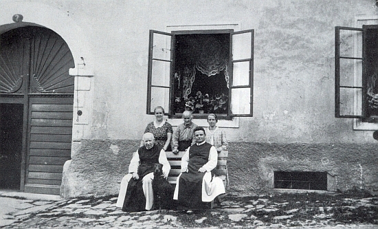 Před hořickou farou sedí vedle něho vlevo Paulus Heinrich a za nimi stojí
ženský hospodyňský personál, zleva Rehbergová, (Anna) Kernová a Wößová