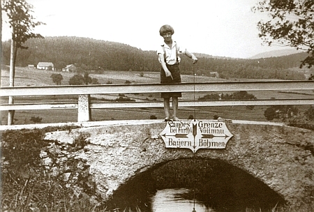 Snímek z doby kolem roku 1920 s hraničním mostkem a ukazateli na něm