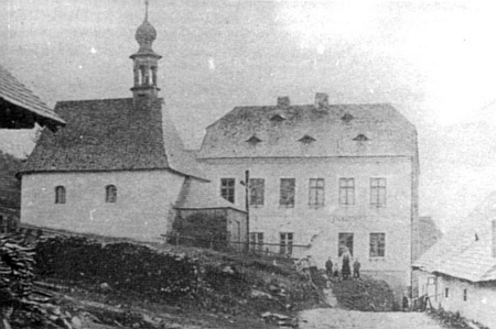 Kaple sv. Šebestiána ve Stodůlkách a zaní zdejší škola na snímku z dvacátých let 20. století